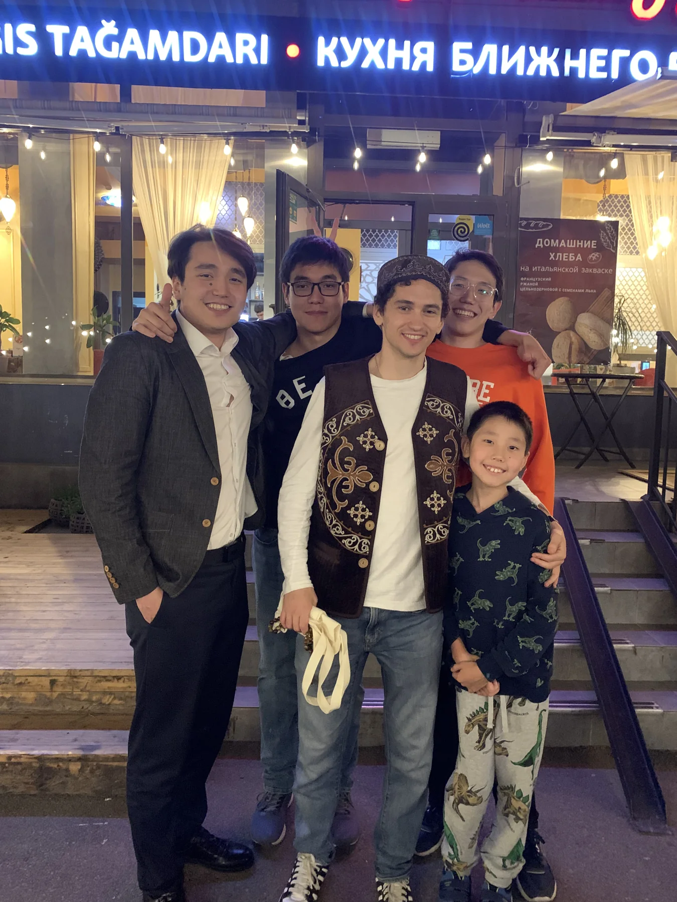 Jack with friends outside a restaurant with Kazakh and Russian signage
